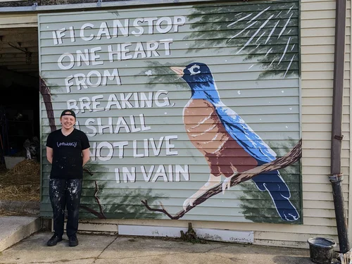 Me, the artist, standing in front of the finished robin mural.